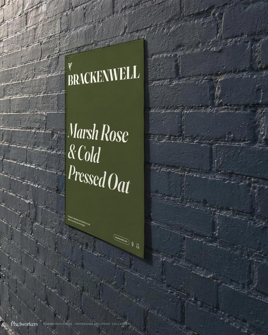 A skincare carton face in deep olive and cream, pasted as a poster on a dark brick street wall.