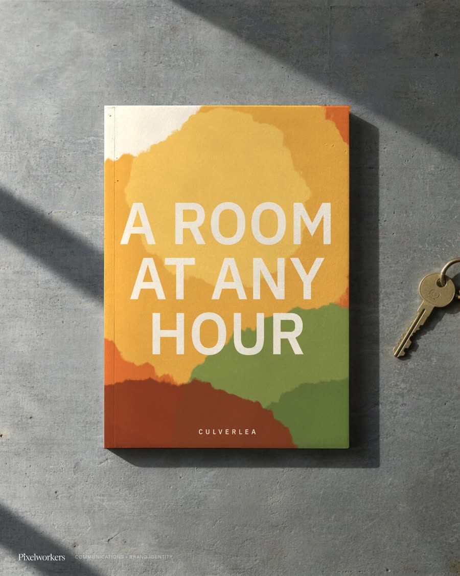 A branding cover for a ferry-terminal stopover hotel, laid flat on a sunlit zinc counter beside its room key.