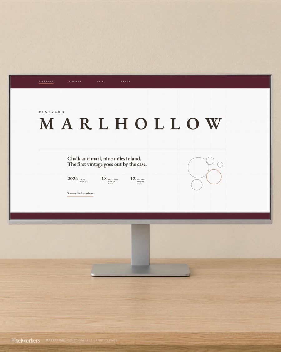 A vineyard's landing hero shown on a monitor, the estate name set wide above its first-release facts.
